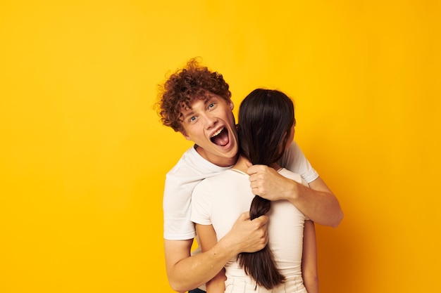 Joli jeune couple se serrant les uns les autres dans des t-shirts blancs fond isolé inchangé