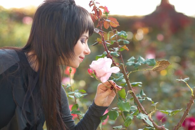 Joli jeune portrait en plein air avec une fleur rose rose dans le parc