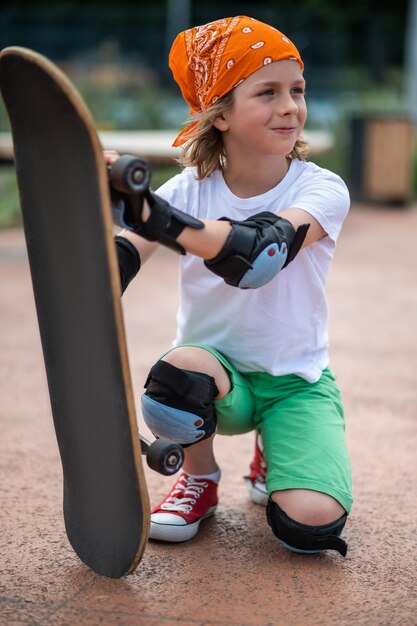 Joli jeune skateur paisible avec sa planche