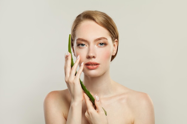 Joli mannequin avec une peau claire et une plante d'aloès verte Concept de soins de peau et de soins du visage