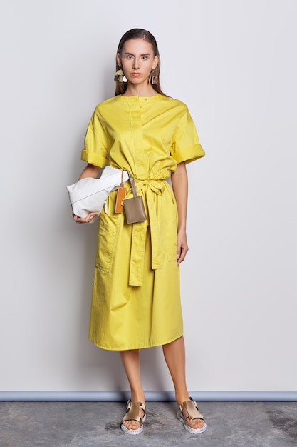 Joli mannequin en robe jaune avec sac à main