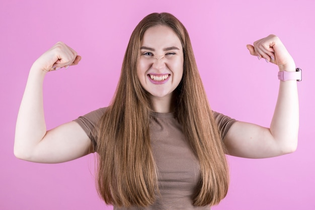 Le joli modèle reste en forme et en bonne santé, lève les bras et démontre les muscles