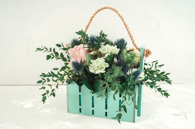 Joli panier de couleur turquoise avec un bouquet. Fleurs de mariage pour la décoration de restaurant