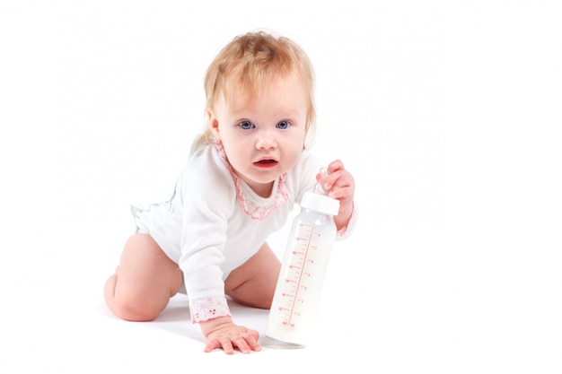Joli petit bébé heureux en chemise blanche avec du lait