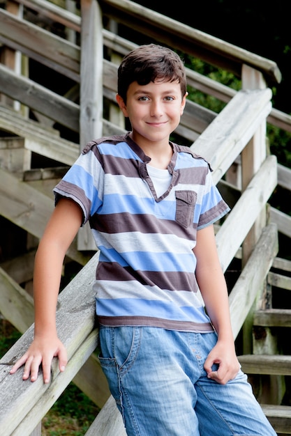 Joli preteen garçon souriant dans les escaliers en bois