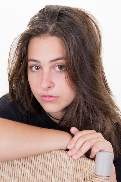 Jolie adolescente aux cheveux longs, assis sur une chaise en studio sur une décoration blanche de Hanoukka