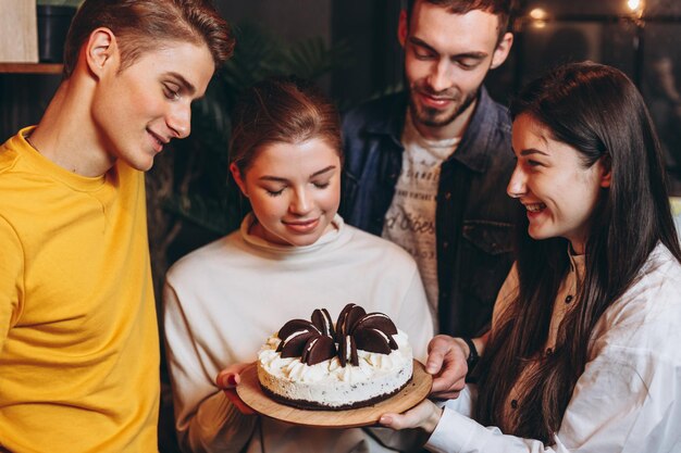 Jolie adolescente célébrant son anniversaire avec un gâteau avec ses meilleurs amis