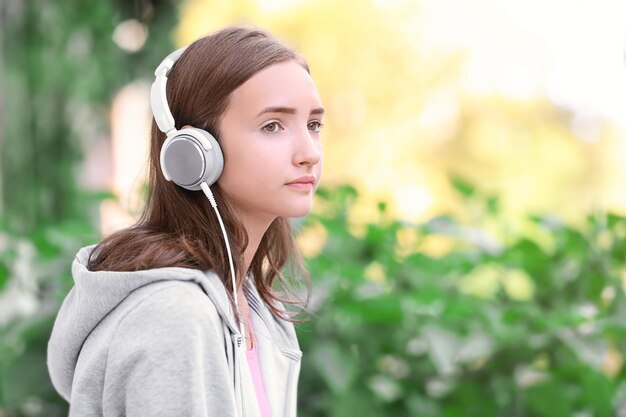 Jolie adolescente écoutant de la musique à l'extérieur