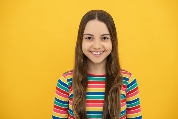 Jolie adolescente headshot portrait Adorable petite fille enfant isolé sur fond jaune