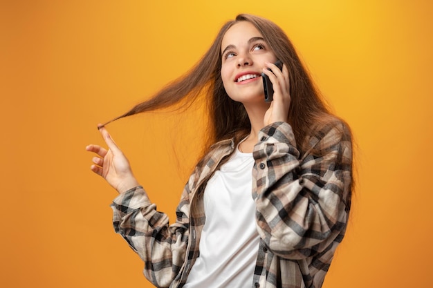 Jolie Adolescente Parlant Au Téléphone Portable Sur Fond Jaune