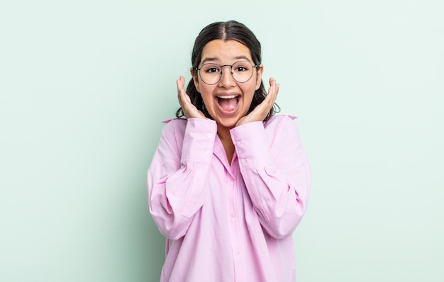 Jolie adolescente se sentant choquée et excitée, riant, étonnée et heureuse à cause d'une surprise inattendue