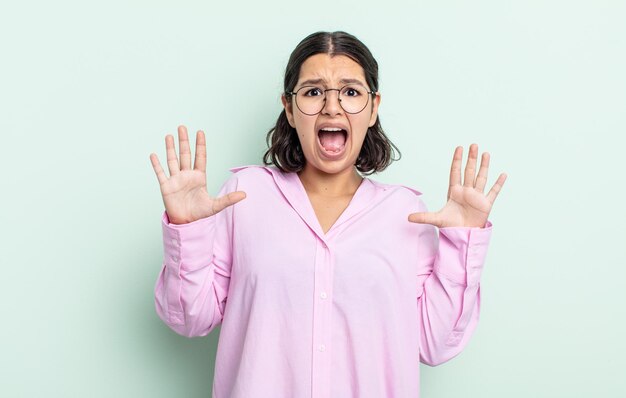 Jolie adolescente se sentant stupéfaite et effrayée, craignant quelque chose d'effrayant, les mains ouvertes devant lui disant de rester à l'écart