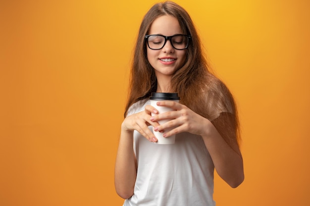 Jolie adolescente avec une tasse de café à la main