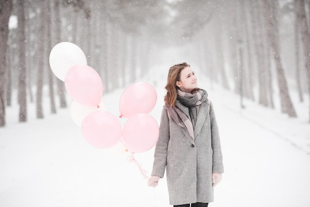 Jolie adolescente tenant des ballons dans le parc