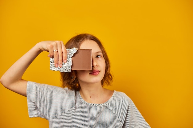 Jolie adolescente avec un visage de couverture de barre de chocolat