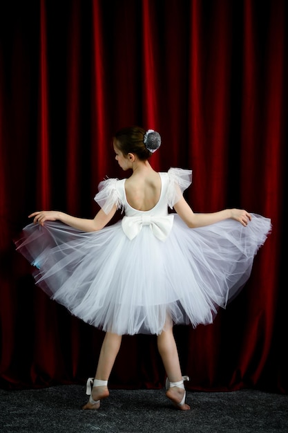 Une jolie ballerine dans une robe blanche sur fond rouge Art Dance Beauty