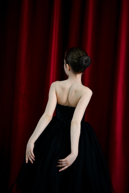 Une jolie ballerine dans une robe noire sur fond rouge Art Dance Beauty