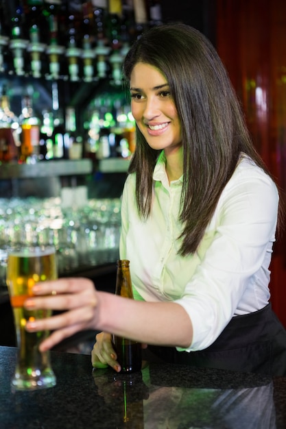 Jolie barman servant de la bière au comptoir