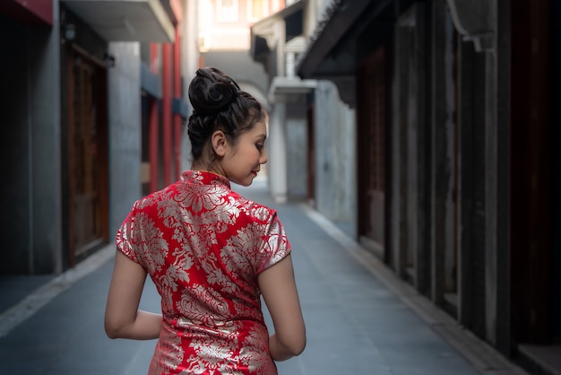 jolie belle fille chinoise vêtue d&#39;une robe rouge Cheongsam debout sur la route en Chine ville