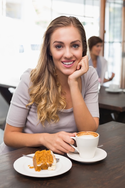 Jolie blonde appréciant le gâteau et le café