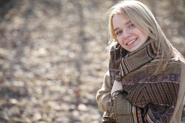 Jolie blonde dans un parc de la ville par une froide journée ensoleillée