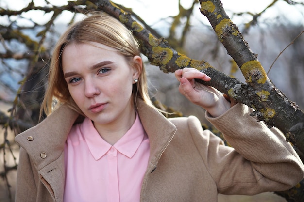 Jolie blonde dans un parc de la ville par une froide journée ensoleillée