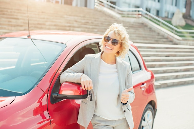 Jolie blonde dans une voiture montrant les clés