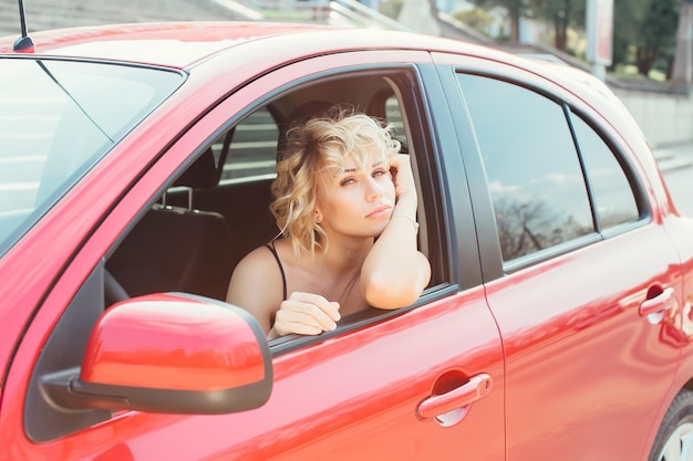 Jolie blonde dans une voiture montrant les clés