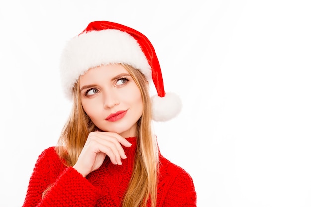 Jolie blonde d'esprit en bonnet de Noel rêvant sur l'espace blanc