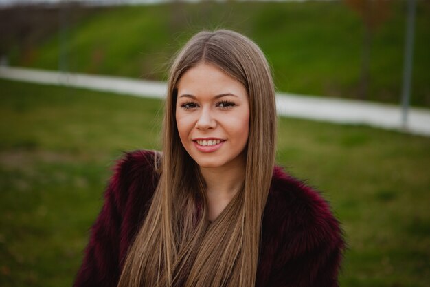 Jolie blonde fille avec un manteau de fourrure