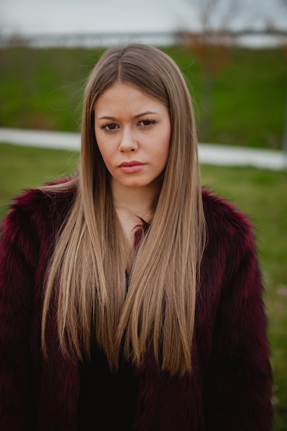 Jolie blonde fille avec un manteau de fourrure