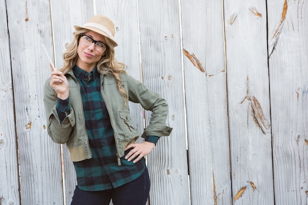 Jolie blonde posant en chapeau et tenant