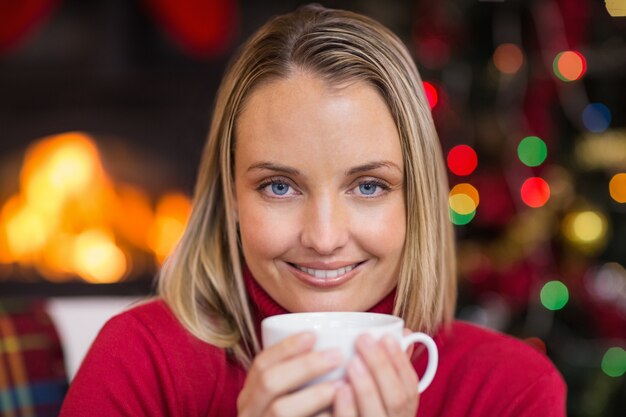 Jolie blonde se détendre sur le canapé à Noël