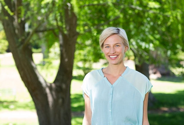 Jolie blonde en souriant à la caméra