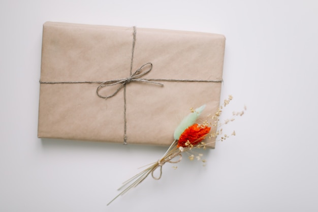 Jolie boîte cadeau enveloppée de papier kraft marron et décorée de jute