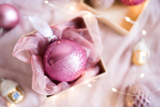 Jolie boule de Noël rose en gros plan sur la boîte. Vacances d'hiver. Vue de dessus.