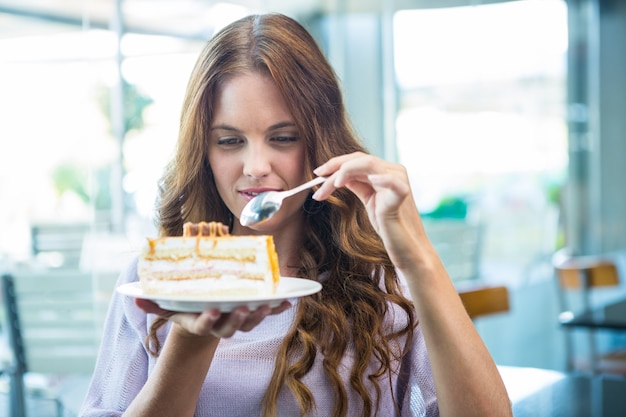 Jolie brune appréciant un gâteau
