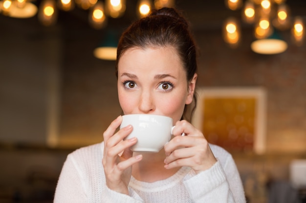 Jolie brune ayant une tasse de café