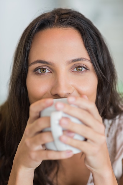 Jolie brune à boire une tasse