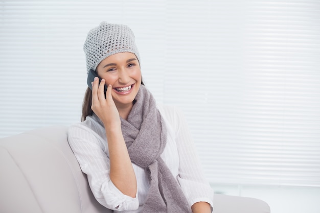 Jolie brune avec un chapeau d&#39;hiver lors d&#39;un appel téléphonique