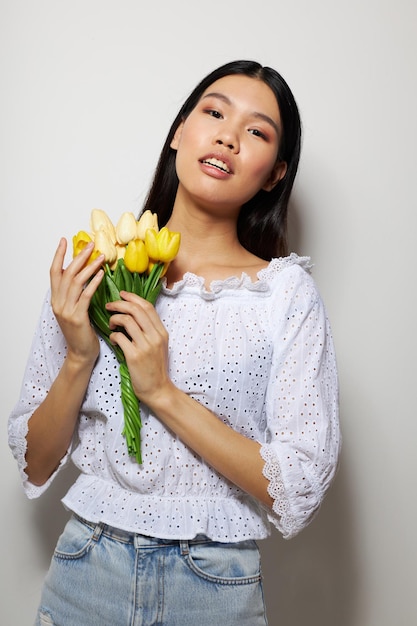 Jolie brune dans une chemise blanche fleurs printemps posant style de vie inchangé