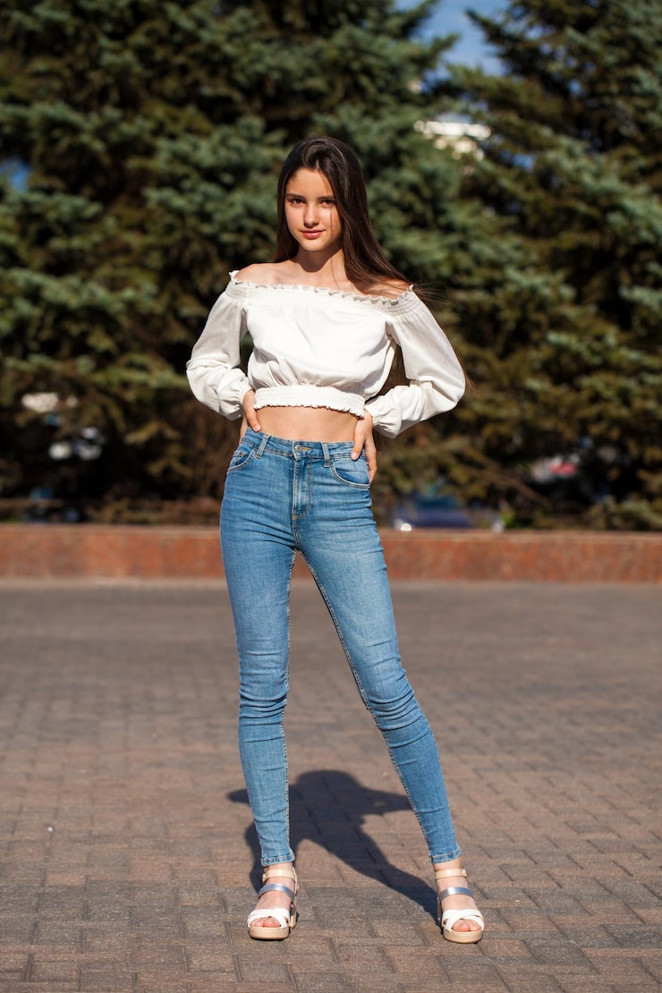Photo une jolie brune élégante en jean bleu et en chemise blanche.