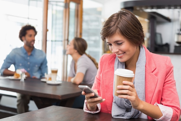 Jolie brune envoie un texte, boire du café