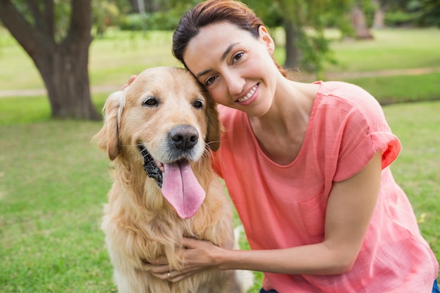 Jolie brune en regardant la caméra avec son chien