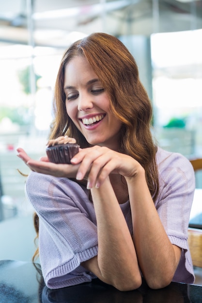 Jolie brune regardant cupcake