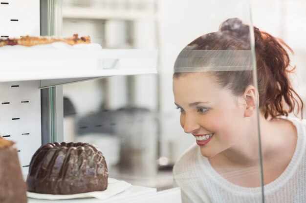 Jolie brune regardant le gâteau