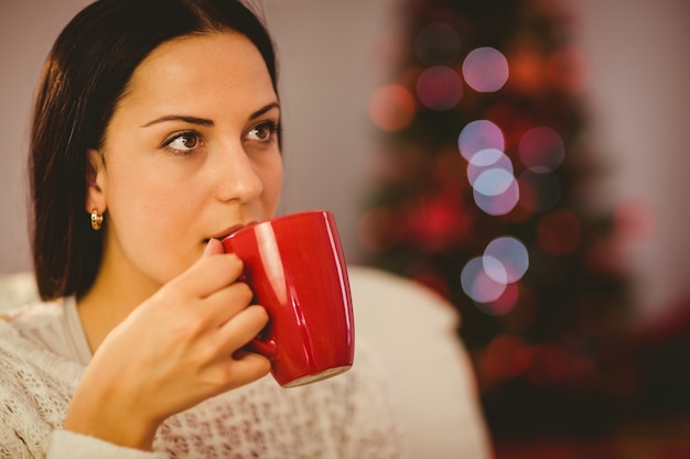 Jolie brune se détendre sur le canapé à Noël