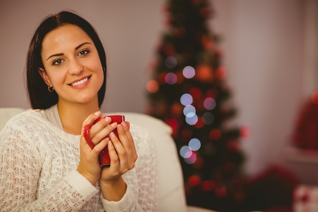 Jolie brune se détendre sur le canapé à Noël