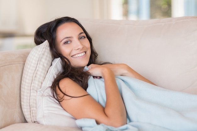 Jolie brune se détendre sur le canapé