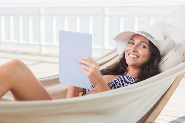 Jolie brune se détendre sur un hamac et à l&#39;aide de tablet pc